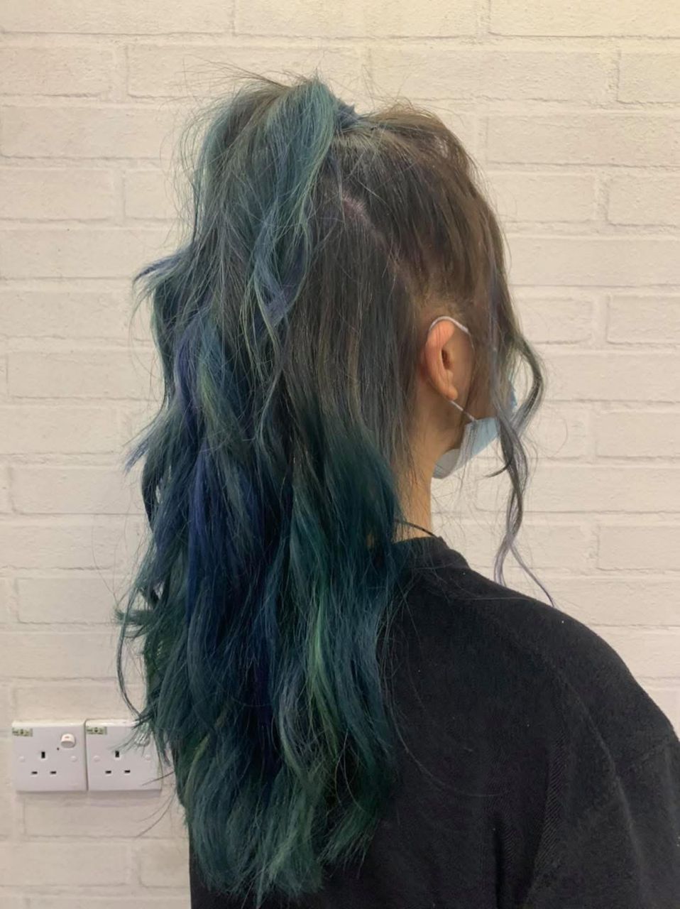 Stylist working through long glossy hair